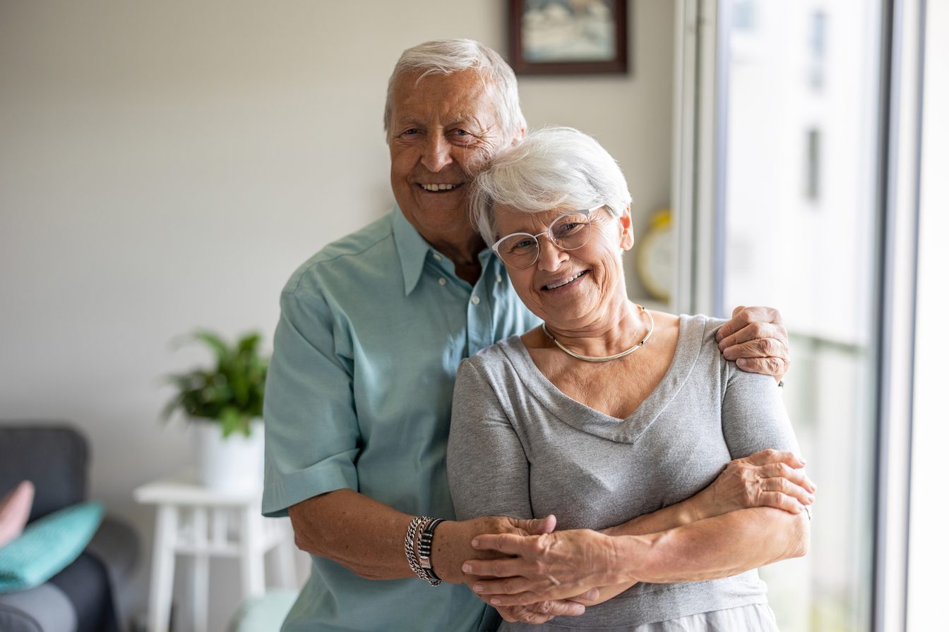 Couple de seniors souriants à leur domicile